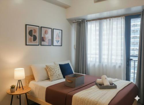 a bedroom with a large bed and a window at Makati Business District Prime Accommodations in Manila