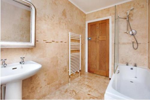 ein Badezimmer mit Waschbecken, Dusche und Spiegel in der Unterkunft 3 bedroom Family home in Budleigh Salterton, Devon in Budleigh Salterton