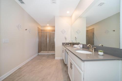 a bathroom with a sink and a large mirror at 800MO VILLA 5 BED/5 BA in Orlando