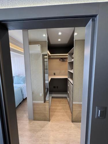 een kamer met een bed en een inloopkast bij Apartamento Novo no Melhor Bairro de Londrina in Londrina