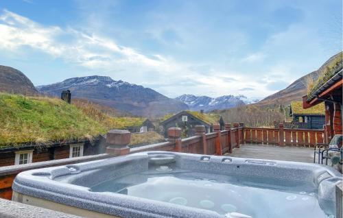 a hot tub on a deck with mountains in the background at 3 Bedroom Beautiful Home In Straumgjerde in Brunstad
