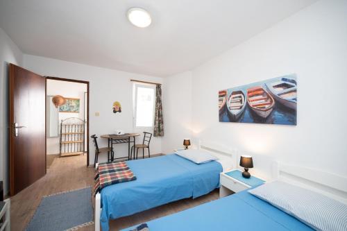 ein Schlafzimmer mit 2 Betten und einem Tisch mit einem Tisch in der Unterkunft Apartment Zaglav 8170b in Sali