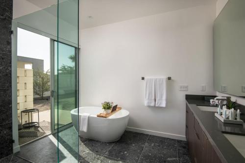 a bathroom with a tub and a glass shower at Krypton @ Elemento49 Pool Spa Sleeps 16 in Desert Groves Mobile Home Park