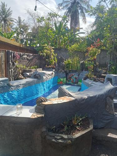a backyard with a swimming pool and a water slide at ATB Hostel in Lovina