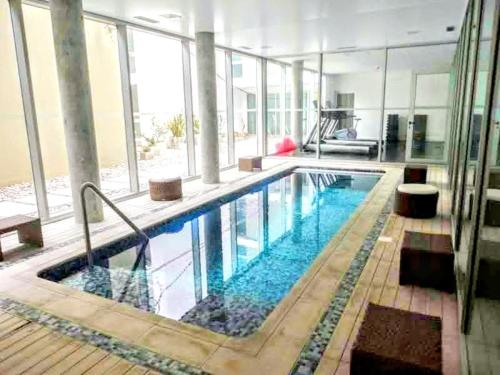 a large swimming pool in a large building at Apto 210 Un Refugio luminoso frente a la playa in Colonia del Sacramento