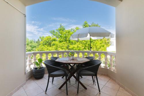 een balkon met een tafel en stoelen en een parasol bij Apartments with parking space Muline, Ugljan - 8521 in Donje Selo