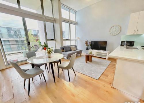 a kitchen and a living room with a table and chairs at Modern Two-Level Apartment in the Heart of Epping in Epping