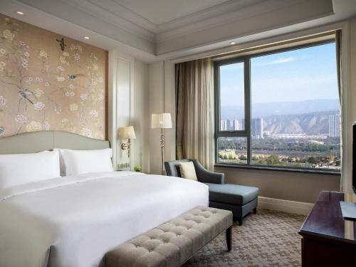 a hotel room with a bed and a large window at The Sebel Xining-Managed By Sofitel in Xining