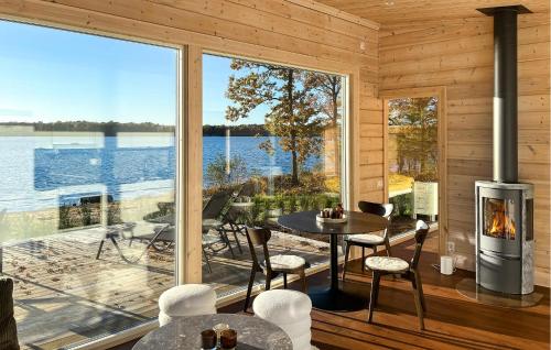 a room with a fireplace and a view of the water at Gorgeous Home In Bolmsö With Lake View in Bolmsö