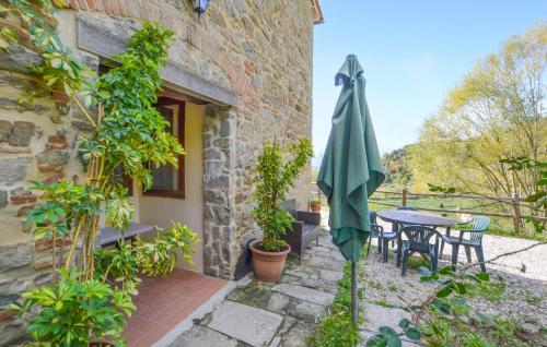 a patio with a table and a green umbrella at Awesome Apartment In Bibbiena in Serravalle