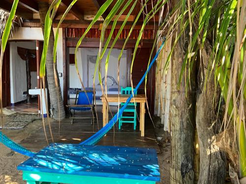 Habitación con mesa, sillas azules y árbol en Bambú Ecocabañas, en San Agustinillo