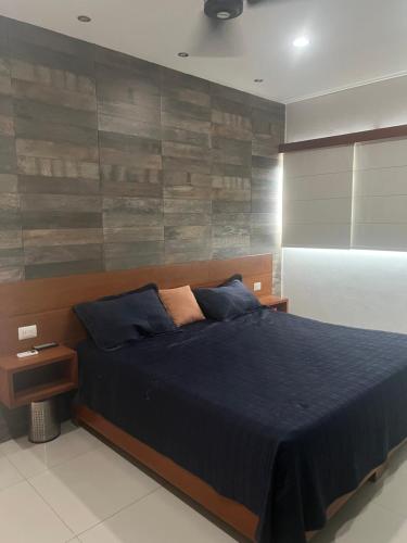 a bedroom with a bed and a wooden wall at Departamento 10 Polanco in Valladolid