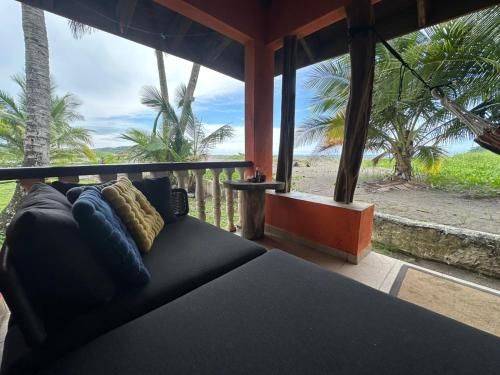 a couch in a room with a view of the ocean at Venao Beachfront Cabana in Playa Venao