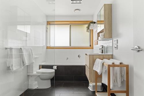 a white bathroom with a toilet and a shower at Bonnie Belle, Norwood in Kings Meadows