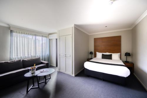 a hotel room with a bed and a couch at Crest on Barkly Hotel in Melbourne