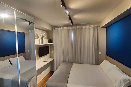 a small bedroom with a bed and a tv at Flat em São Paulo - Completo e Acolhedor in São Paulo
