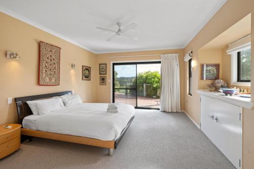 a bedroom with a bed and a sliding glass door at Yallingup Valley Views in Yallingup