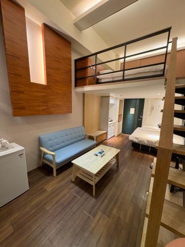 a living room with a couch and a bunk bed at 泡個澡溫泉民宿 in Jiaoxi