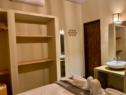 a bathroom with a sink and a bed with towels at The Jungle, Guriú, CE in Guriú