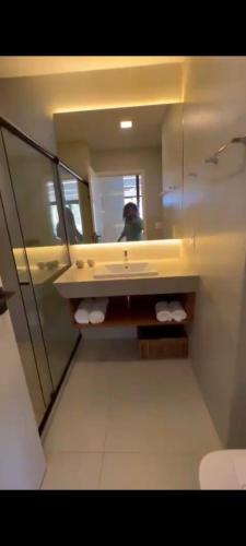 une personne prenant une photo dans un miroir de salle de bains dans l'établissement Resort porto life2, à Ipojuca