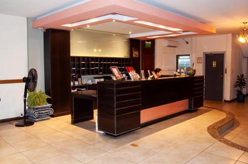 a woman sitting at a bar in a hotel lobby at Hotel Bulevar in Paysandú