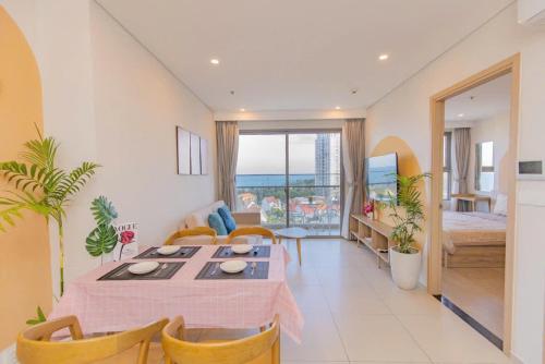 a living room with a table and chairs and a bedroom at The Sóng Apartment Vũng Tàu - Nhà Chill in Vung Tau