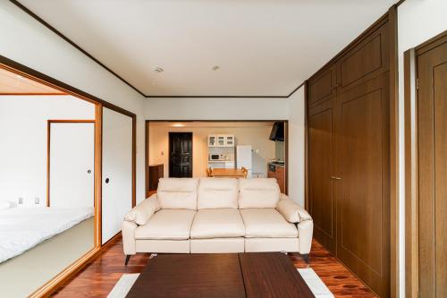 a white couch in a room with a bedroom at Luce Ikebukuro - Cozy APT Stay in Ikebukuro Tokyo, with Direct Access to Shinjuku & Shibuya in Tokyo