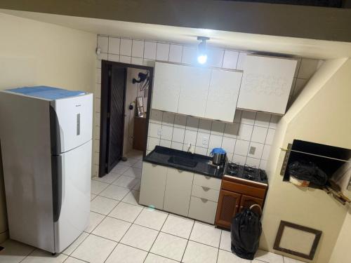 een kleine keuken met een koelkast en kasten bij Apartamento Dúplex in Cidreira