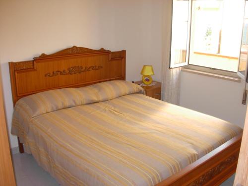 una camera da letto con un letto con un piumone a righe e una finestra di Casa Vacanze Serena ad Alcamo Marina