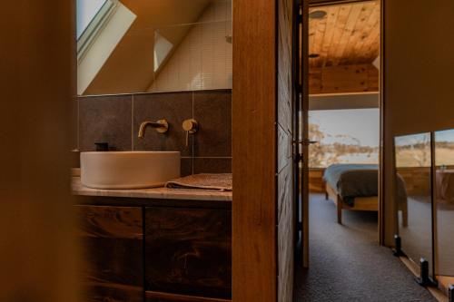 a bathroom with a sink and a bed in a room at Swan River Sanctuary in Swansea