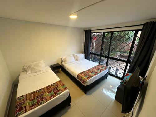 a hotel room with two beds and a window at Bamuka Hostal in Bogotá