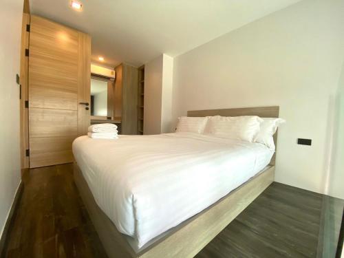 a bedroom with a large bed with white sheets and pillows at utopia naihan in Phuket Town