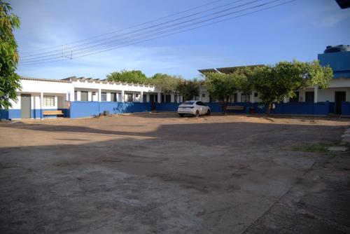 a car parked in a parking lot in front of a building at Hotel Sinhozinho in Coxim