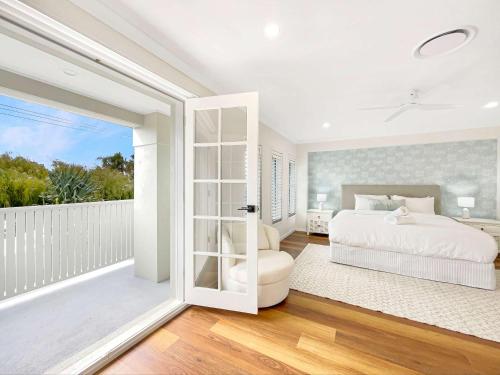 a bedroom with a bed and a balcony at Relaxed Luxury for Families by the Beach in Buddina