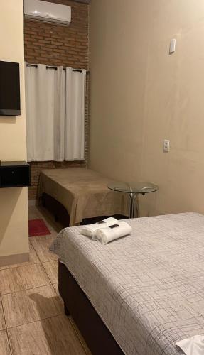 a hotel room with two beds and a television at BR 153 Hotel in Hidrolândia