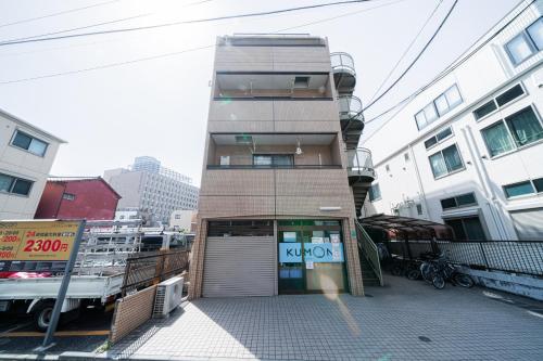 a tall building with a door in a city at Luce Ikebukuro - Cozy APT Stay in Ikebukuro Tokyo, with Direct Access to Shinjuku & Shibuya in Tokyo