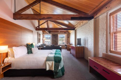 ホバートにあるザ ヘンリー ジョーンズ アート ホテルの部屋の中に大きなベッドがある寝室