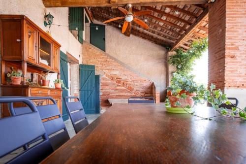 a ceiling fan in a room with a table and chairs at Chemin des Dames - Gite in Montauban