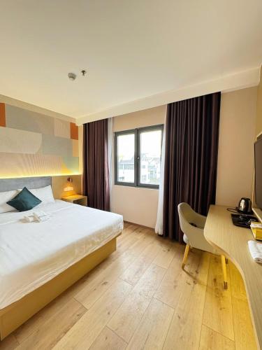 a hotel room with a bed and a desk at ELONG me hotel in Ho Chi Minh City