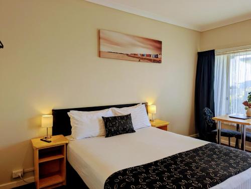 a hotel room with a bed and a window at Ocean Drive Motel in Bunbury