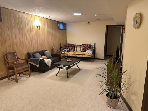 un soggiorno con un divano e una poltrona di Licensed Private Cozy Basement Suite Near Downtown Saskatoon a Saskatoon