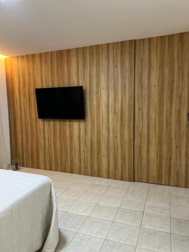 una camera da letto con TV su una parete in legno di Casa barra nova M e Az a Marechal Deodoro