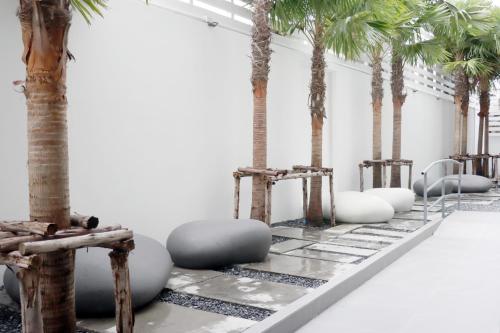 a room filled with palm trees and chairs at UTD8 Hotel and Residence in Bangkok