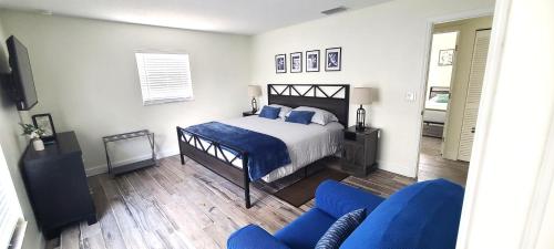 a bedroom with a bed and a blue couch at Lovely House in Sarasota close to UTC Mall Nathan Benderson Park and Siesta Key Beach in Sarasota