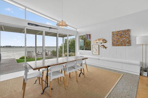 a dining room with a wooden table and chairs at Riverside Retreat - Waterfront - Hindmarsh Island - Linen Included in Hindmarsh Island