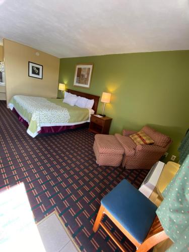 una habitación de hotel con una cama y un sofá en Innkeeper Motel Hamel, en Hamel