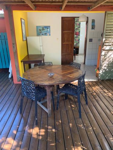 a wooden table and chairs on a deck at Les Manguiers in Deshaies