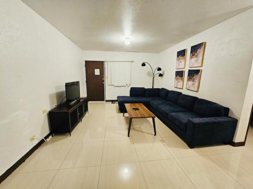 SinajanaにあるPedro's Place 1 bedroom and 1 bathroomの青いソファとテレビのあるリビングルーム