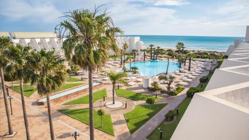 an aerial view of a resort with a swimming pool and the ocean at Iberostar Royal Andalus in Chiclana de la Frontera