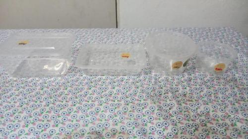 a table topped with plastic containers on a table at Mekong Sedone Hostel Neva Paris in Pakse